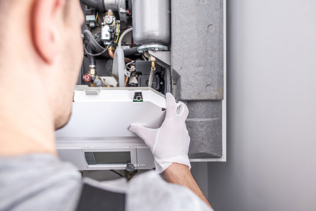 Close-up of a furnace technician working on a furnace.